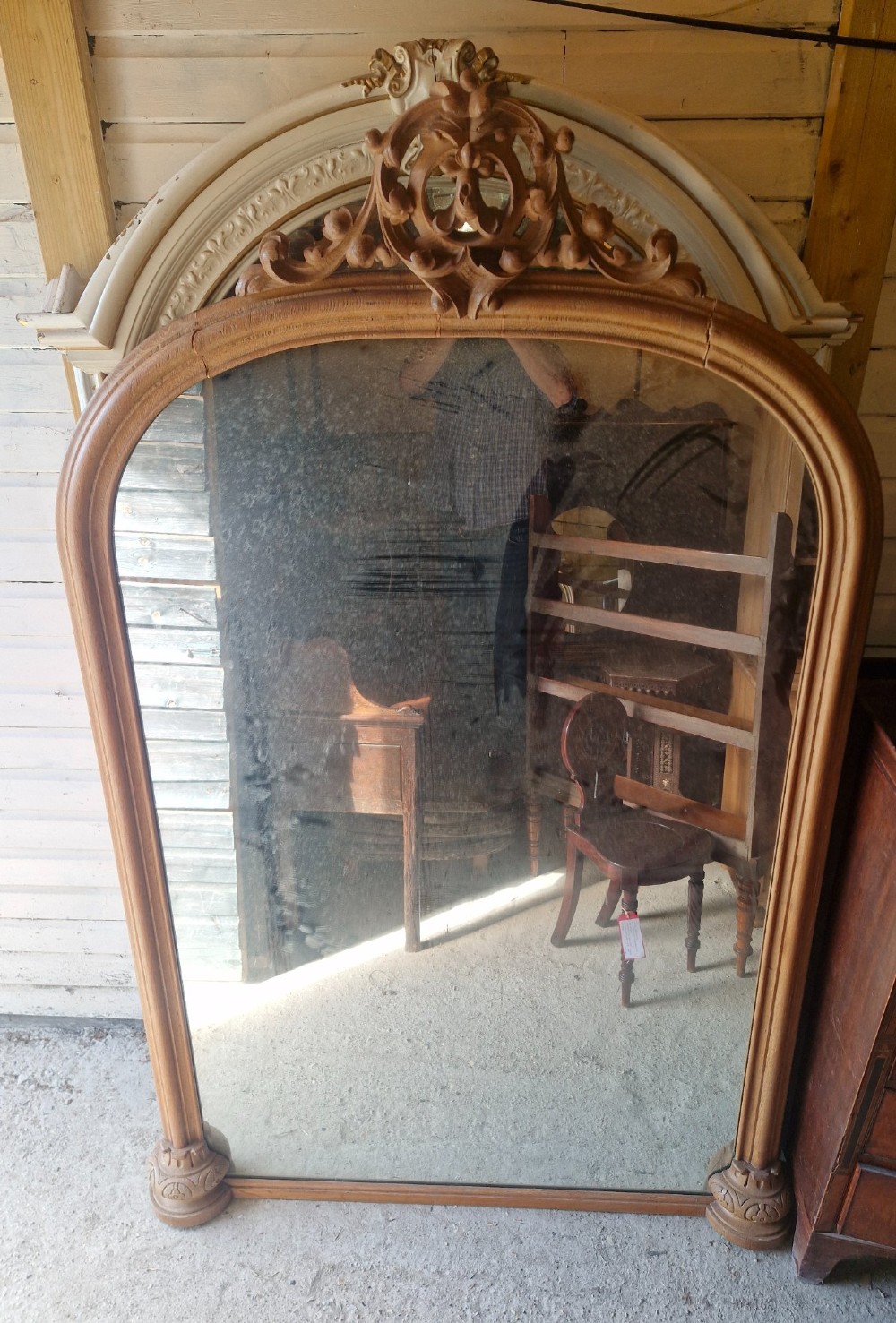 A large 19th-century arched oak wall mirror featuring an intricate carved scrollwork crest and a molded frame. View II