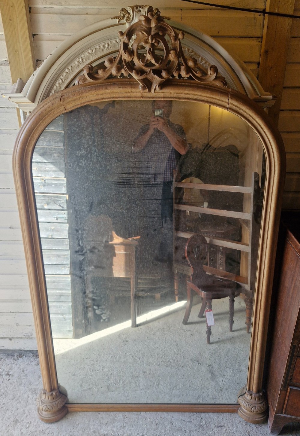 A large 19th-century arched oak wall mirror featuring an intricate carved scrollwork crest and a molded frame. View III