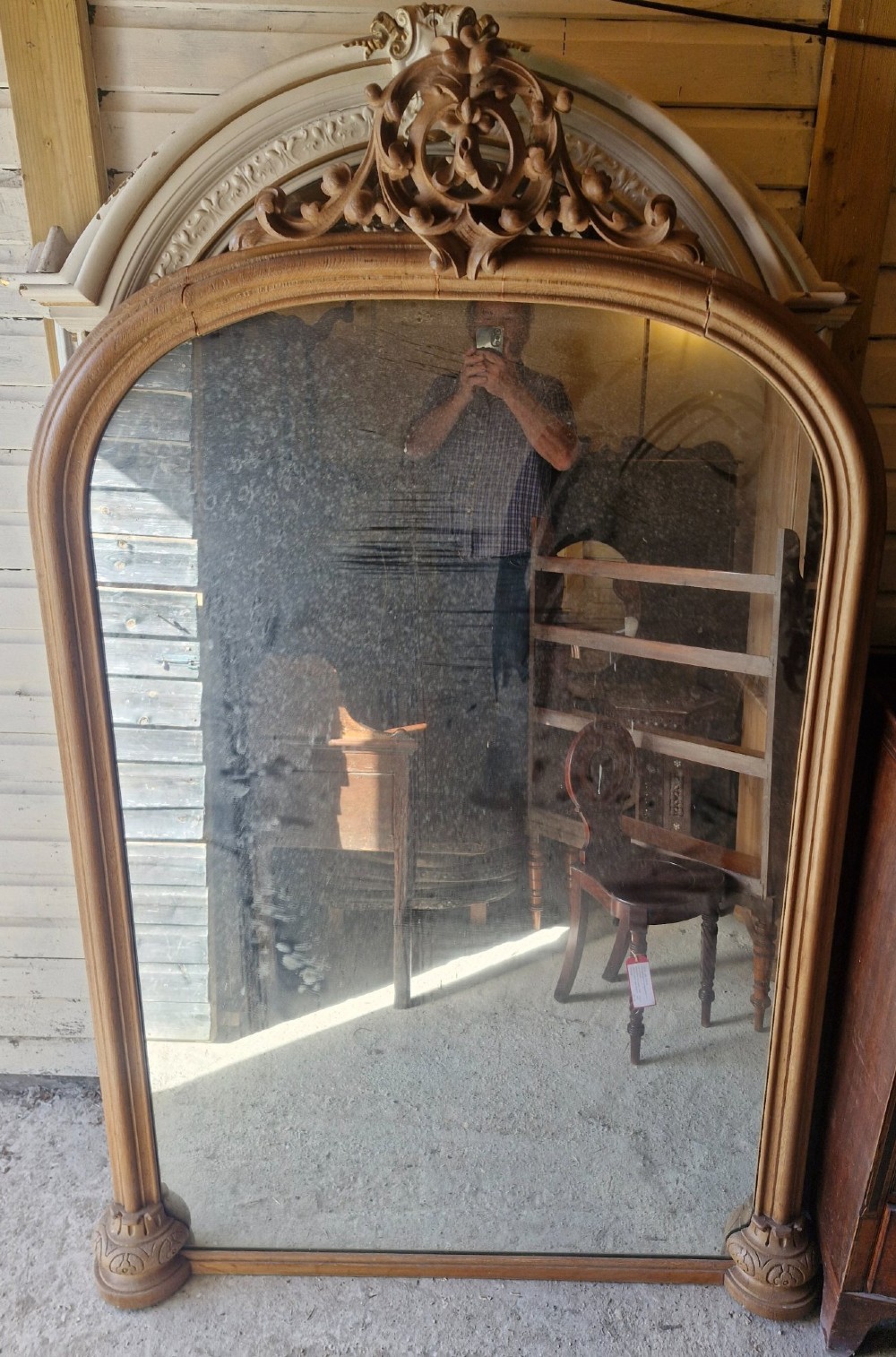A large 19th-century arched oak wall mirror featuring an intricate carved scrollwork crest and a molded frame. View IV
