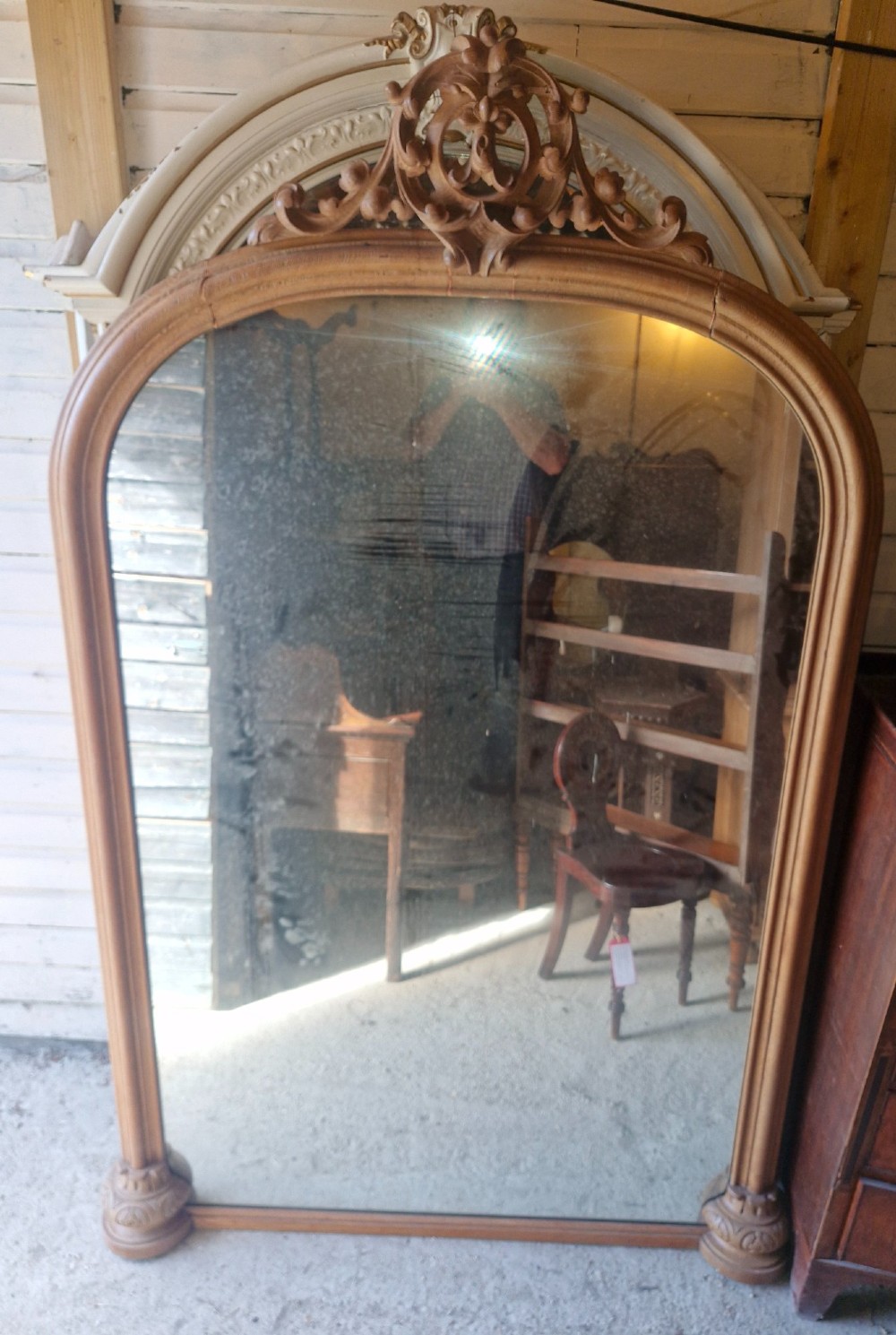 A large 19th-century arched oak wall mirror featuring an intricate carved scrollwork crest and a molded frame. View XI