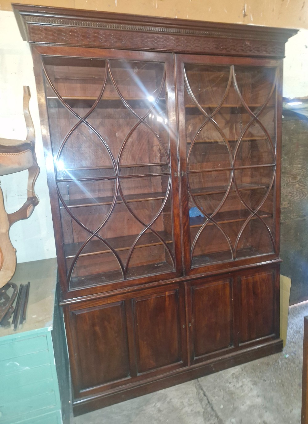 An early 19th-century mahogany library bookcase with double upper glazed doors featuring curved geometric glazing bars over a panelled two-door base. View II