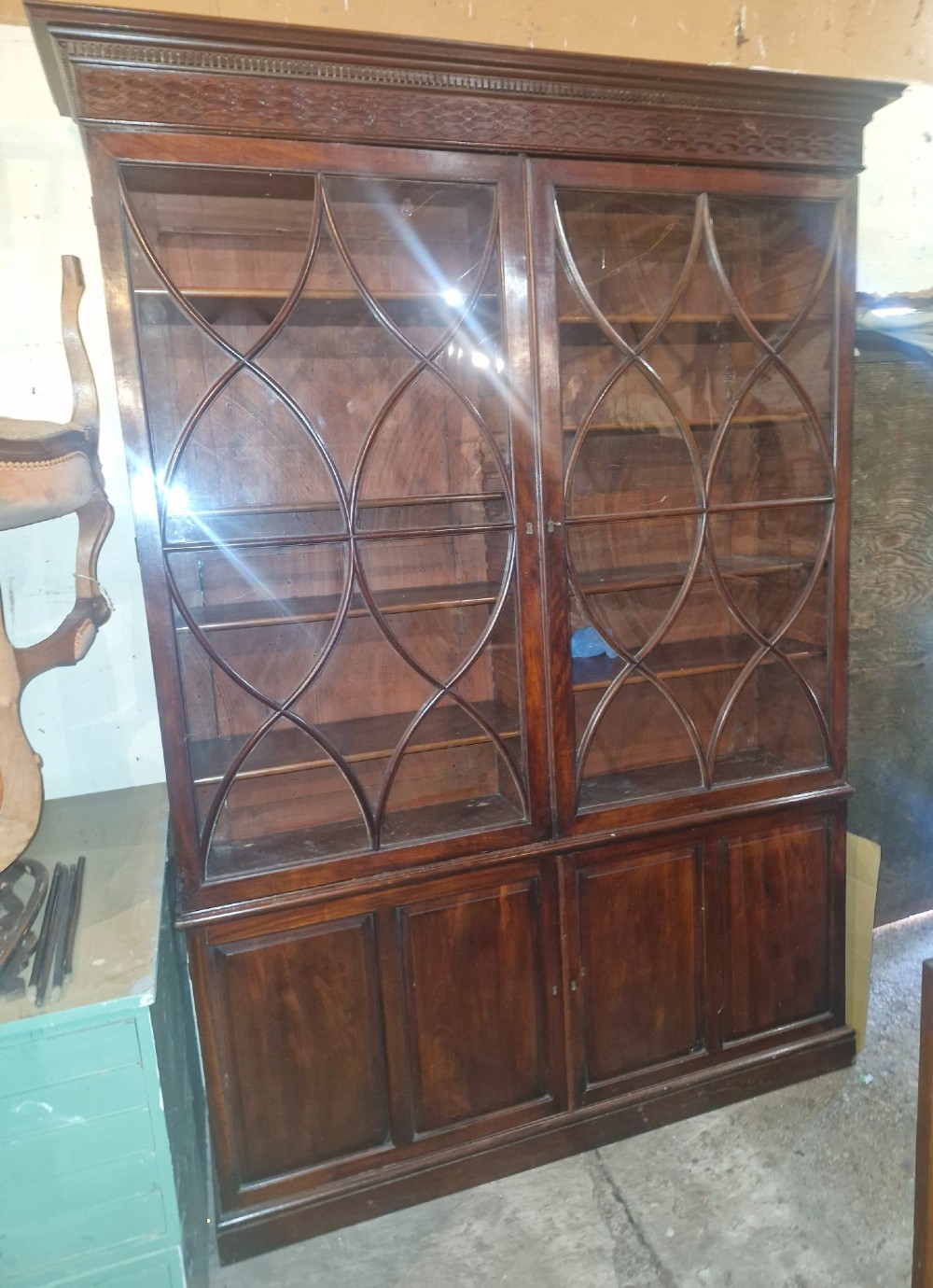 An early 19th-century mahogany library bookcase with double upper glazed doors featuring curved geometric glazing bars over a panelled two-door base. View III