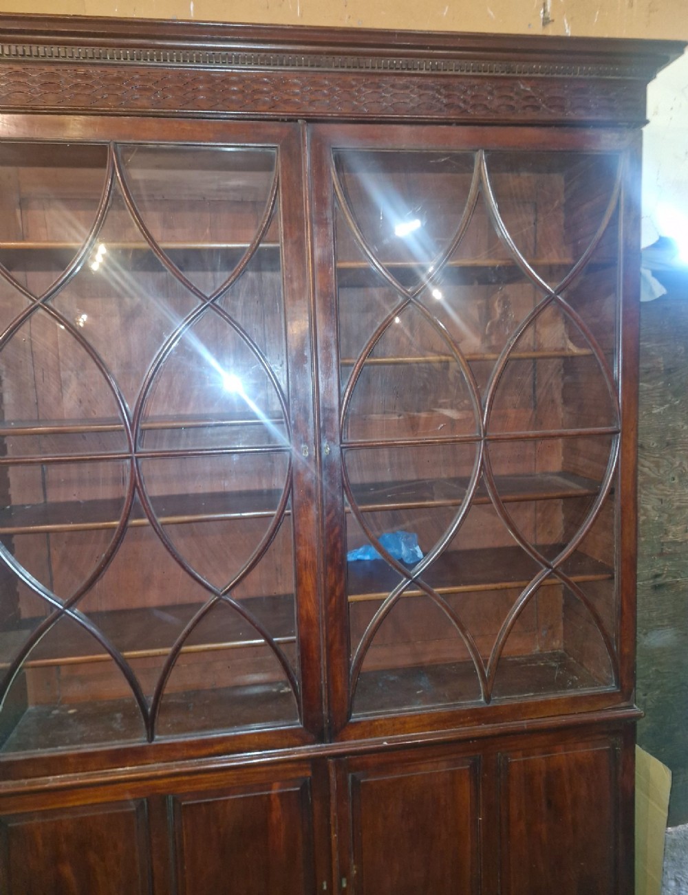 An early 19th-century mahogany library bookcase with double upper glazed doors featuring curved geometric glazing bars over a panelled two-door base. View IV