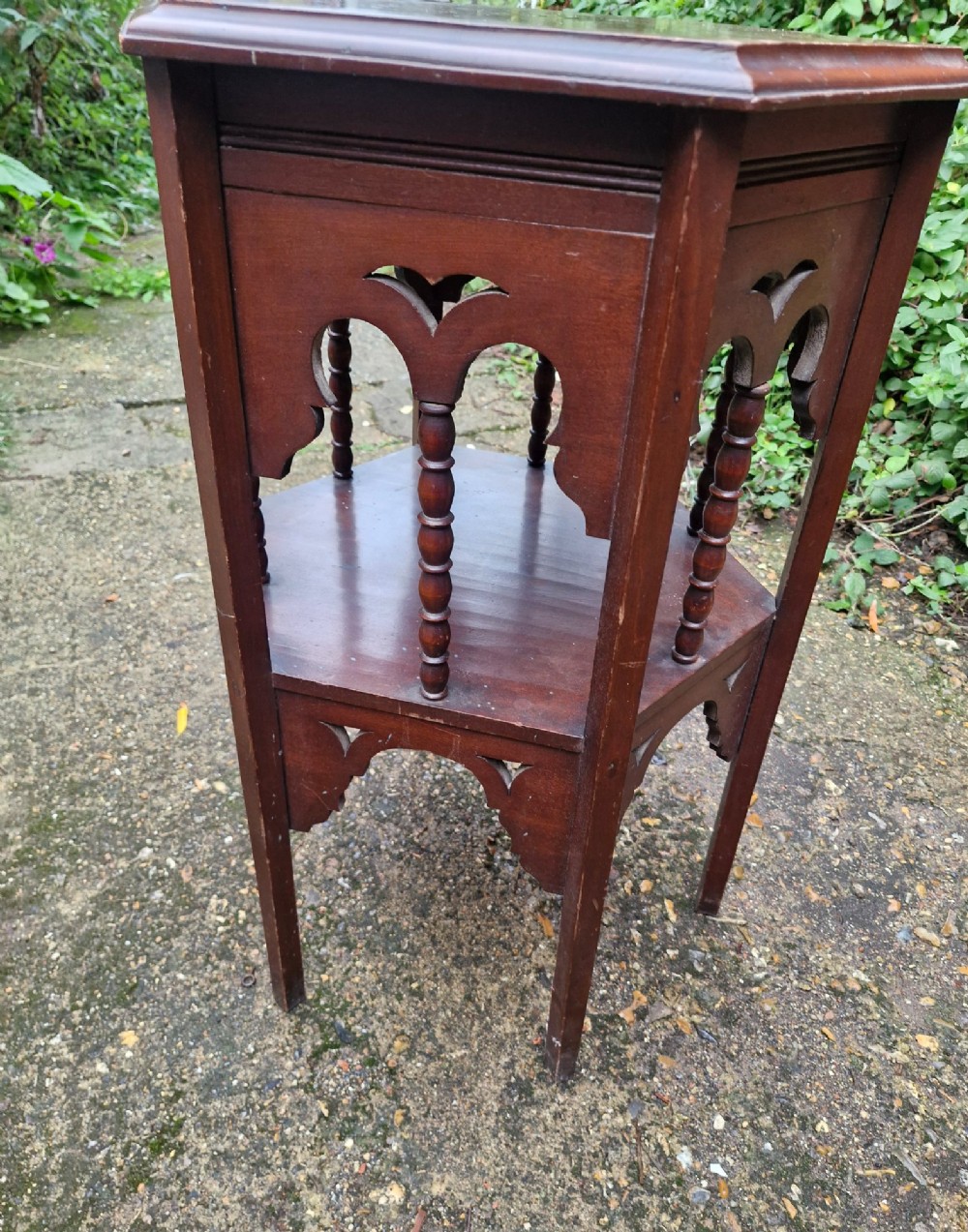 A dark mahogany hexagonal occasional table featuring a lower shelf, turned spindle supports, and cut-out decorative aprons. View III