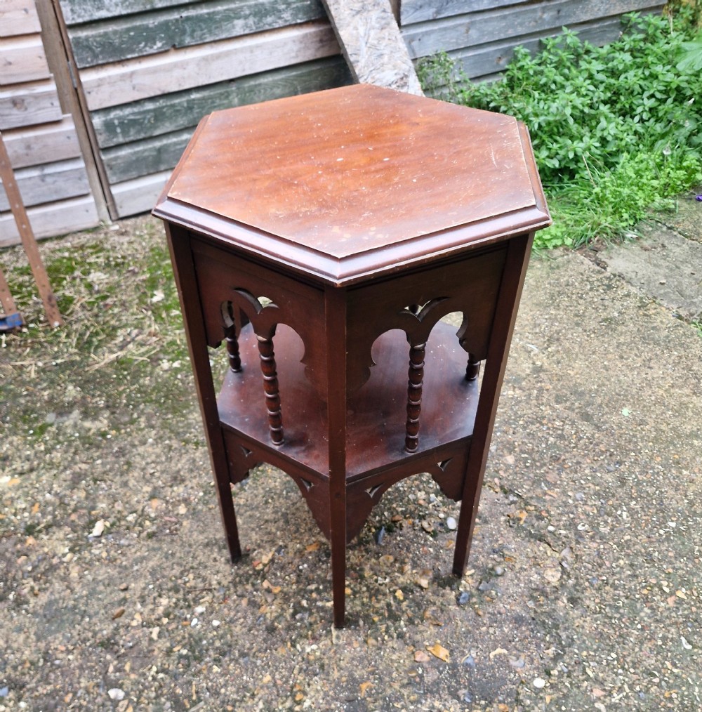 A dark mahogany hexagonal occasional table featuring a lower shelf, turned spindle supports, and cut-out decorative aprons. View XI