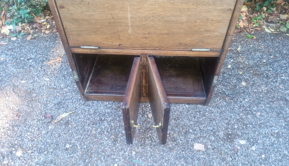 An Edwardian wooden ships washstand featuring an upper arched mirror, a middle drop-front door revealing a white ceramic washbasin, and lower cupboard doors. View VIII