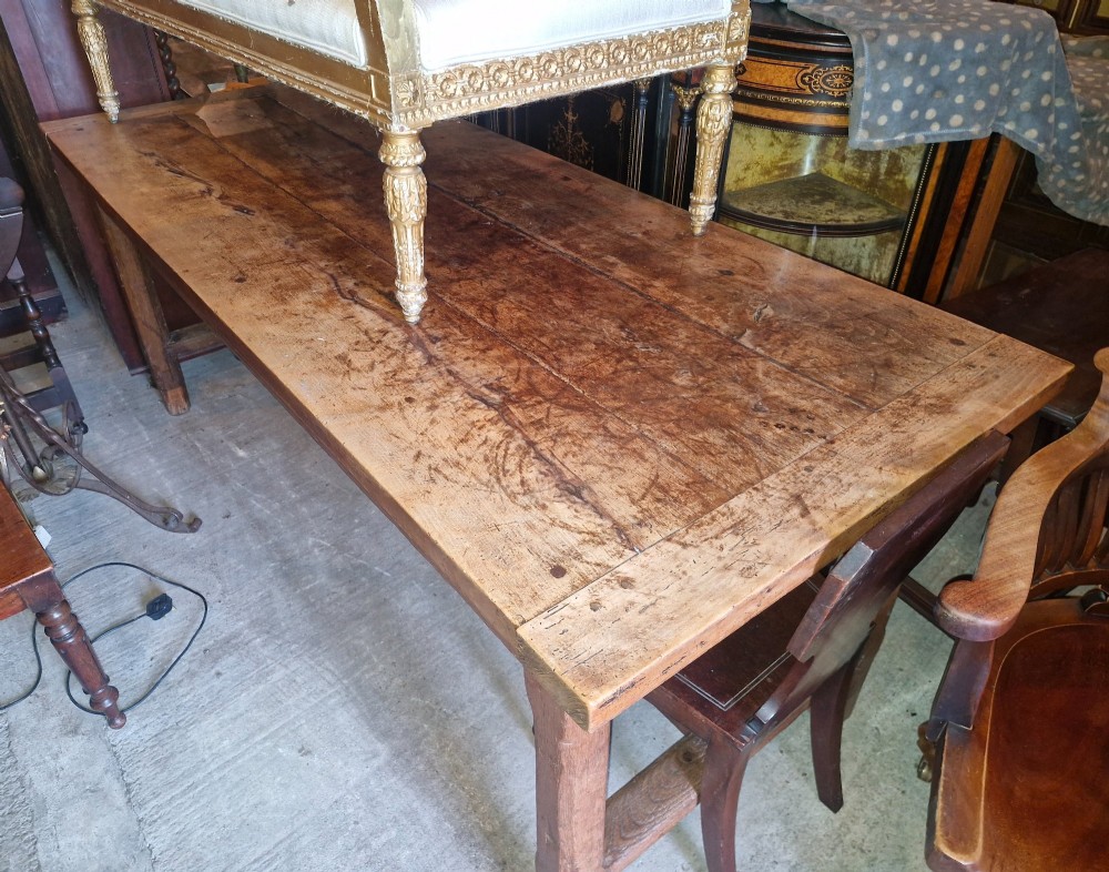 A rustic French farmhouse dining table made of weathered oak with a heavy plank top and sturdy stretcher base. View IX