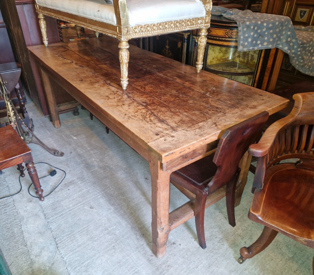 A rustic French farmhouse dining table made of weathered oak with a heavy plank top and sturdy stretcher base. View XI