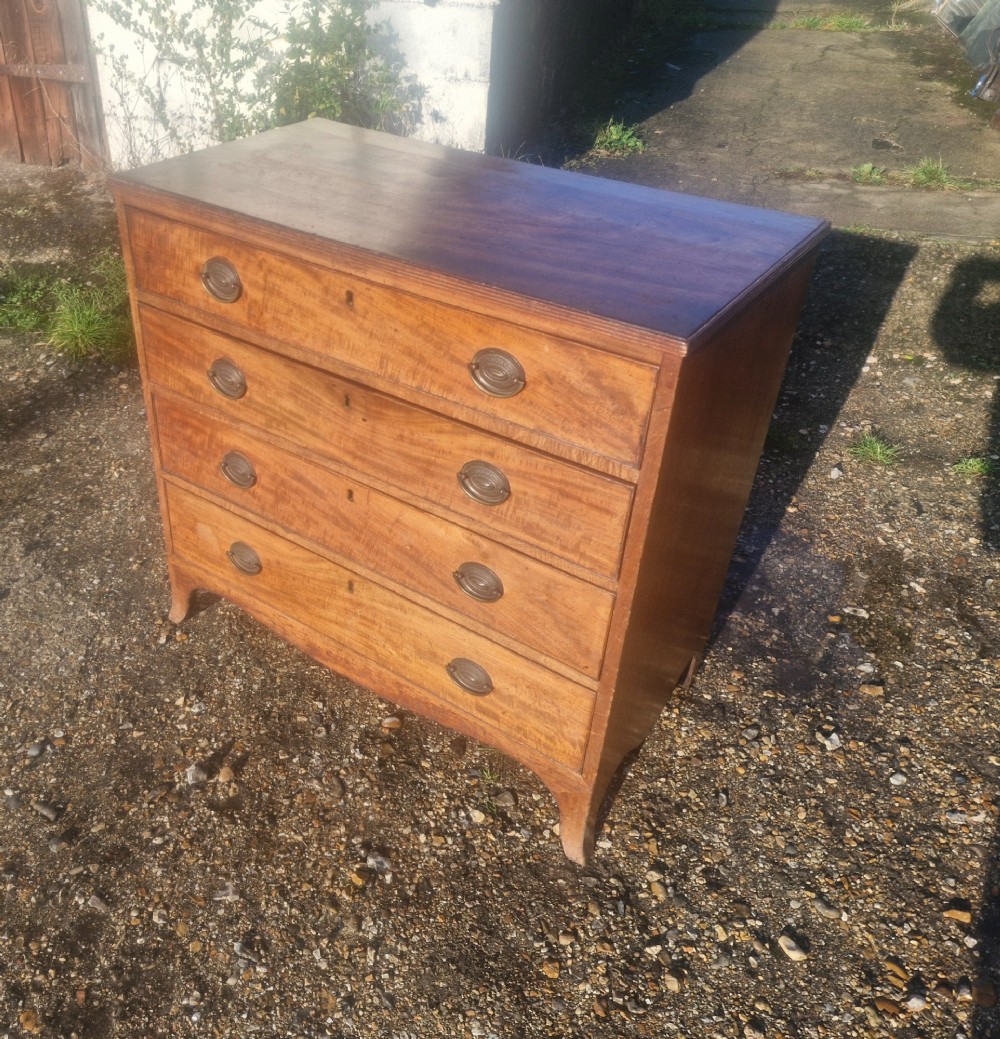 A Regency period mahogany chest of drawers with four graduated drawers, brass oval handles, and splayed bracket feet. View IV
