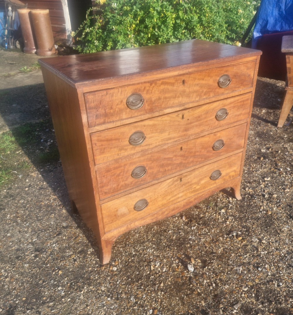 A Regency period mahogany chest of drawers with four graduated drawers, brass oval handles, and splayed bracket feet. View V
