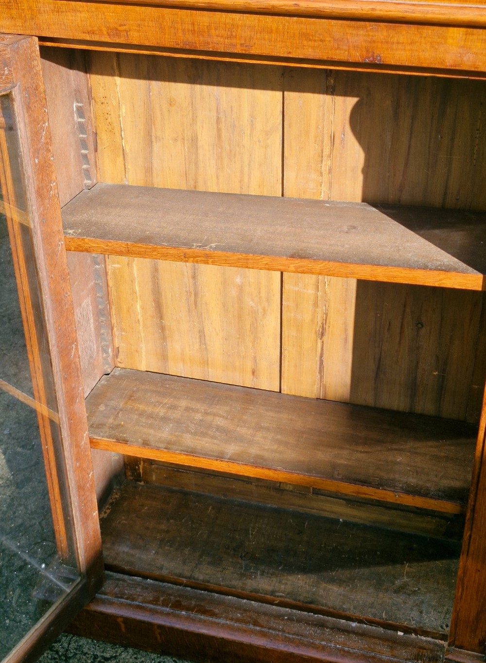 A pair of Victorian low oak bookcases featuring glazed twin doors, brass top gallery rails, carved corbels, and adjustable interior shelving. View X
