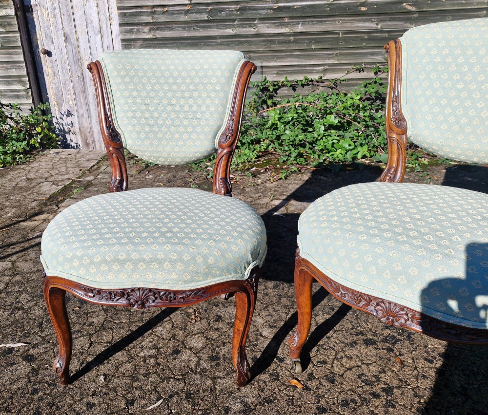 A pair of late Victorian low-seated bedroom chairs with carved walnut frames and light green patterned upholstery. View III