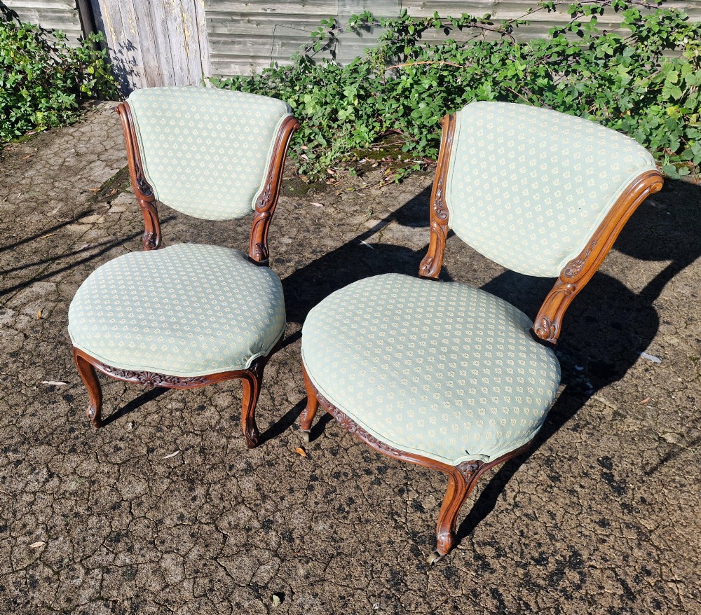 A pair of late Victorian low-seated bedroom chairs with carved walnut frames and light green patterned upholstery. View VI