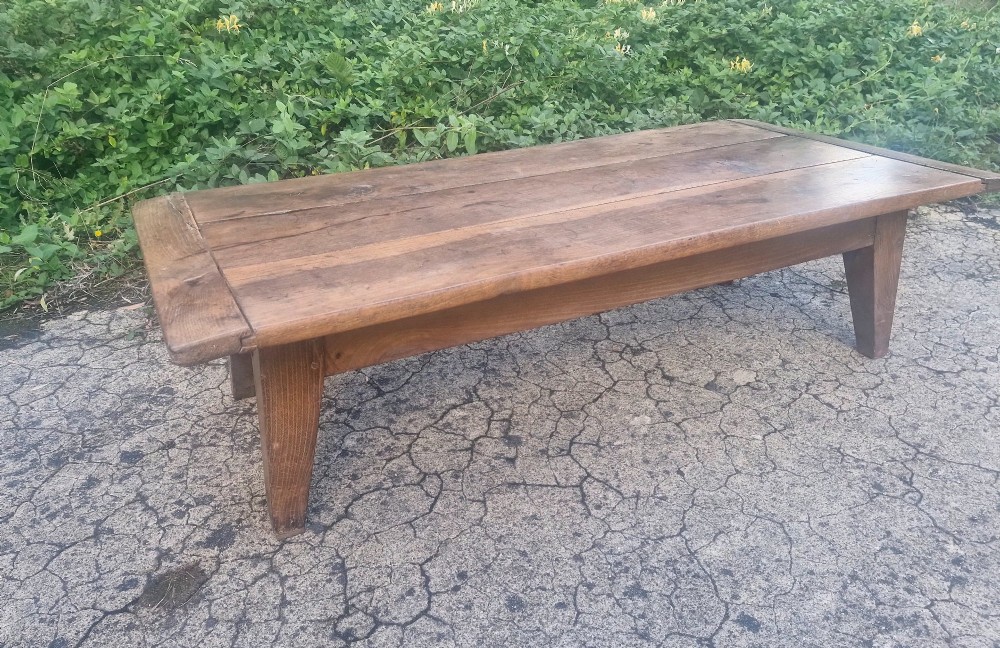 A low rectangular 19th-century oak coffee table featuring a wide plank top with breadboard ends and simple tapered legs. View II