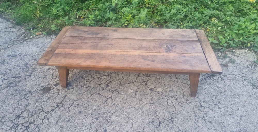 A low rectangular 19th-century oak coffee table featuring a wide plank top with breadboard ends and simple tapered legs. View III