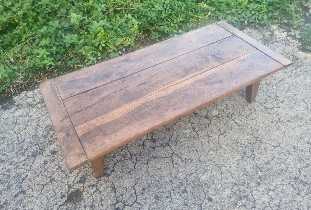 A low rectangular 19th-century oak coffee table featuring a wide plank top with breadboard ends and simple tapered legs. View IV