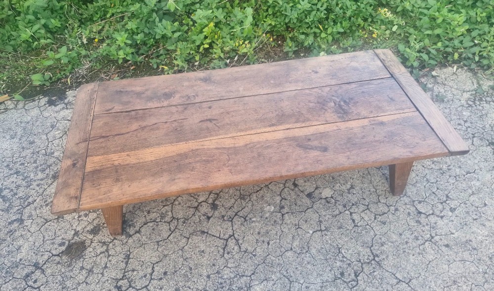 A low rectangular 19th-century oak coffee table featuring a wide plank top with breadboard ends and simple tapered legs. View V