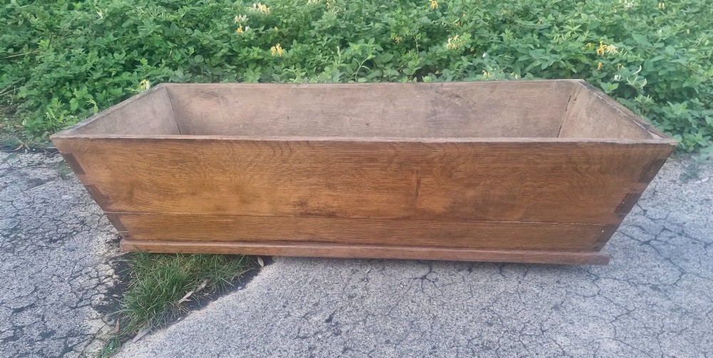 A rectangular open-topped solid oak trough with splayed sides and exposed dovetail joinery. View II