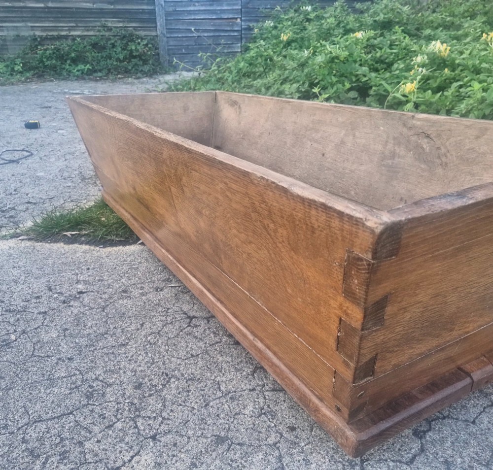 A rectangular open-topped solid oak trough with splayed sides and exposed dovetail joinery. View IV