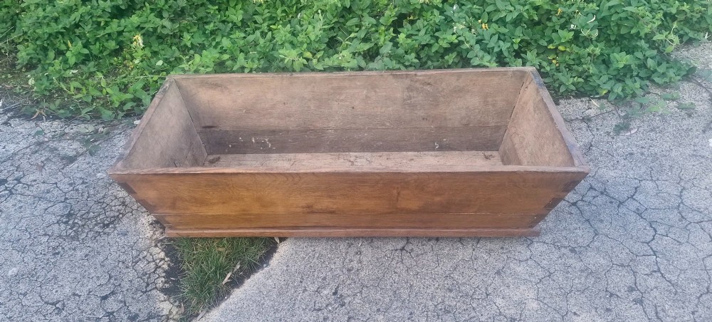 A rectangular open-topped solid oak trough with splayed sides and exposed dovetail joinery. View V