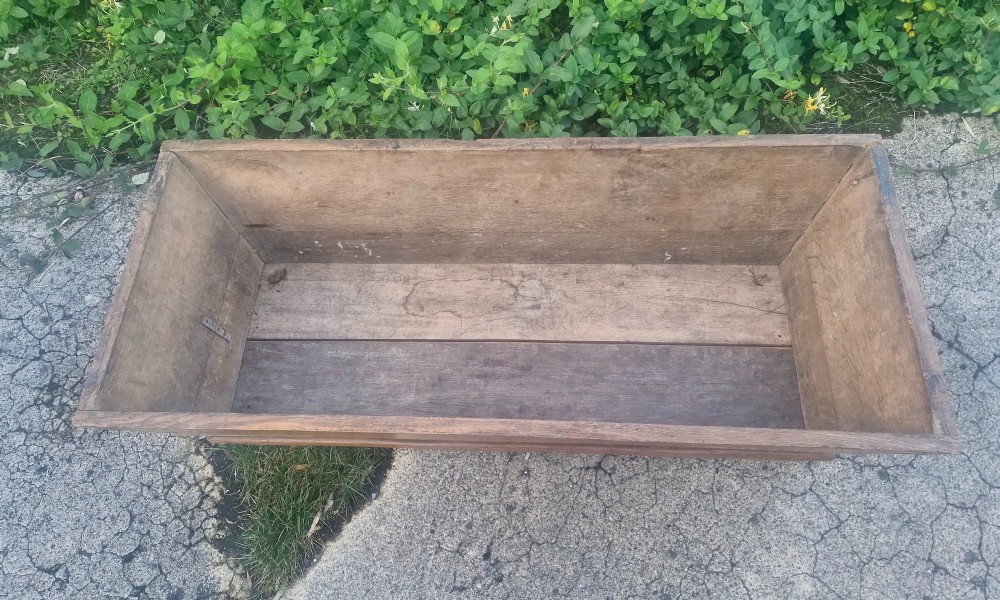 A rectangular open-topped solid oak trough with splayed sides and exposed dovetail joinery. View VI