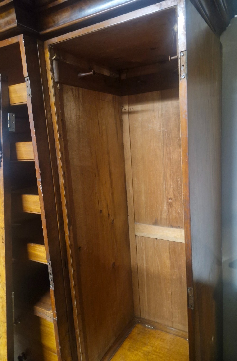 A large Victorian breakfront wardrobe crafted from highly figured burr walnut with two central mirrored doors and carved scrollwork details. View IX