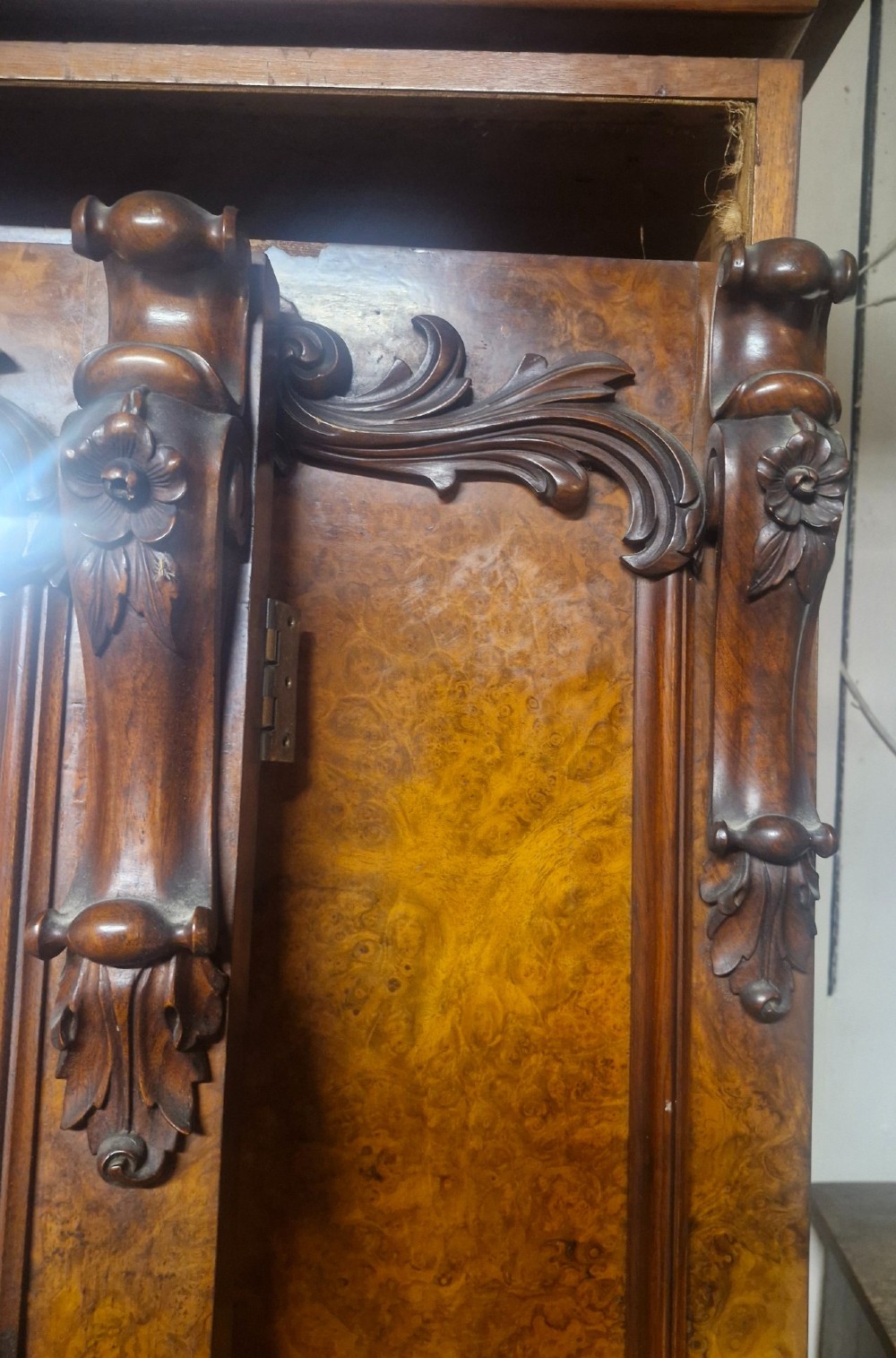 A large Victorian breakfront wardrobe crafted from highly figured burr walnut with two central mirrored doors and carved scrollwork details. View XI