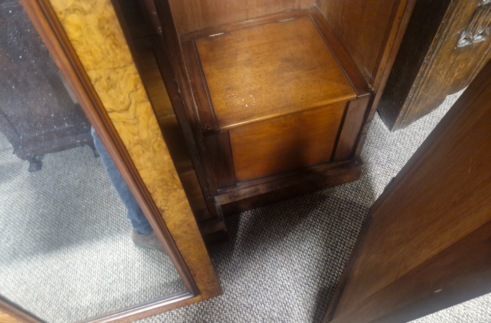 A large Victorian breakfront wardrobe crafted from highly figured burr walnut with two central mirrored doors and carved scrollwork details. View XII