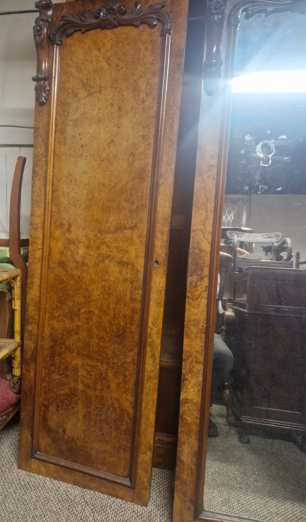 A large Victorian breakfront wardrobe crafted from highly figured burr walnut with two central mirrored doors and carved scrollwork details. View XIV