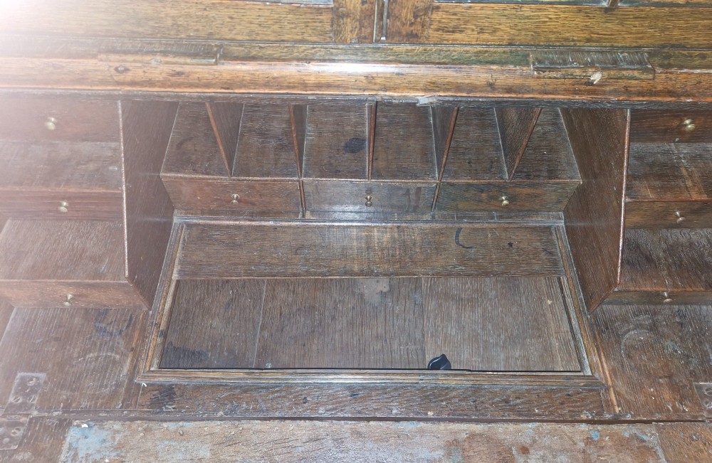 An antique oak bureau bookcase featuring a two-door glazed upper section, a slant-front writing desk, candle slides, and lower drawers raised on bun feet. View VI