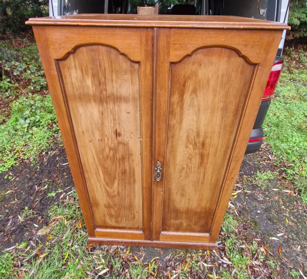 An open twin-door mahogany valet cupboard revealing an internal trouser press mechanism with brass turn-screws and integrated hanging racks. View V