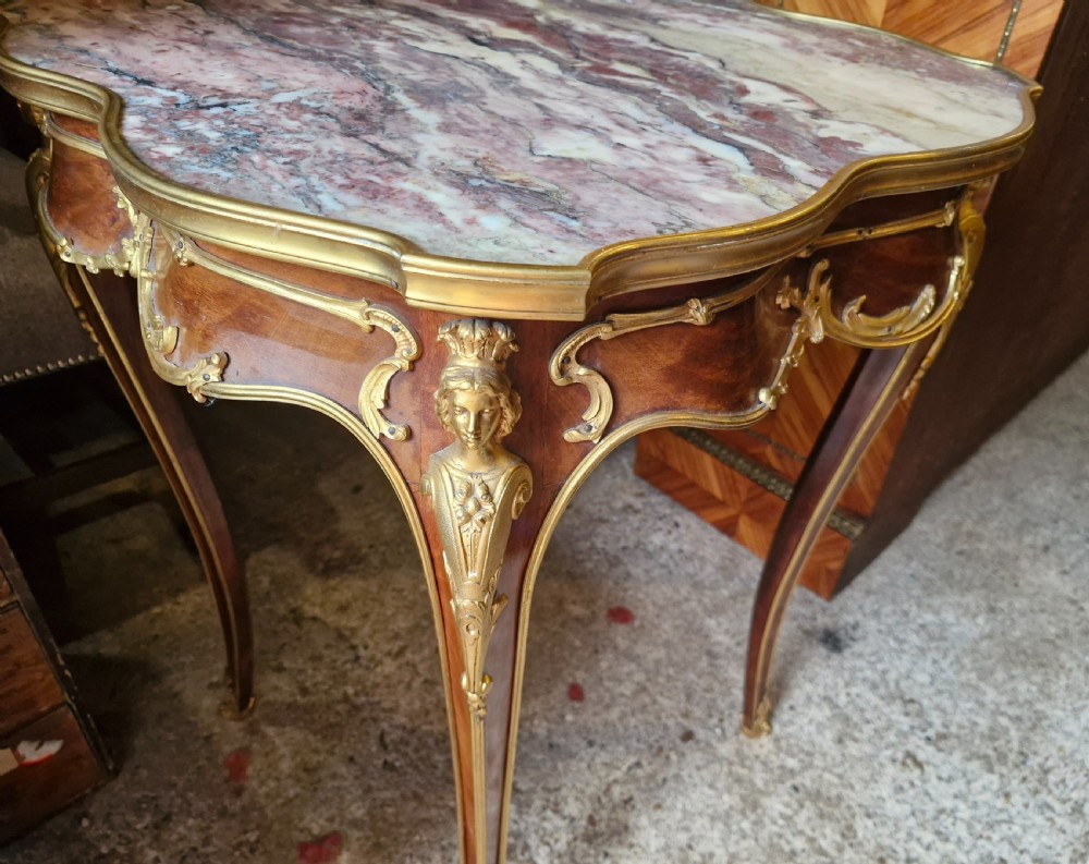 A French Louis XV style side table featuring a shaped variegated pink marble top, slender cabriole legs, and decorative gilt bronze mounts. View III