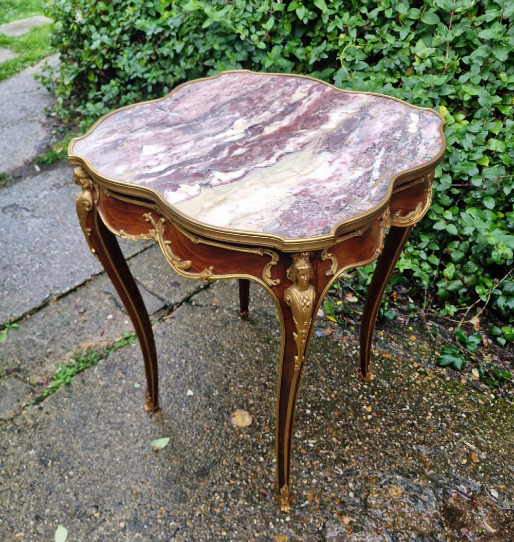 A French Louis XV style side table featuring a shaped variegated pink marble top, slender cabriole legs, and decorative gilt bronze mounts. View VI