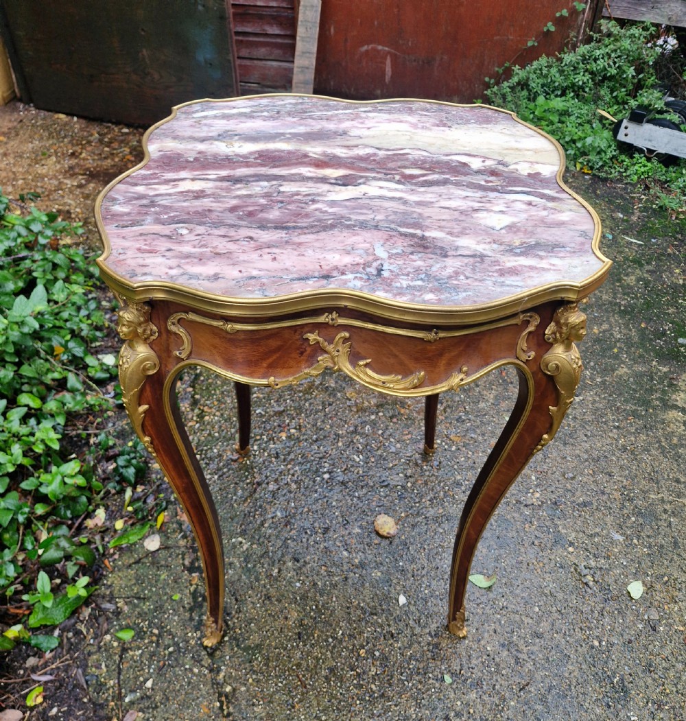 A French Louis XV style side table featuring a shaped variegated pink marble top, slender cabriole legs, and decorative gilt bronze mounts. View VII
