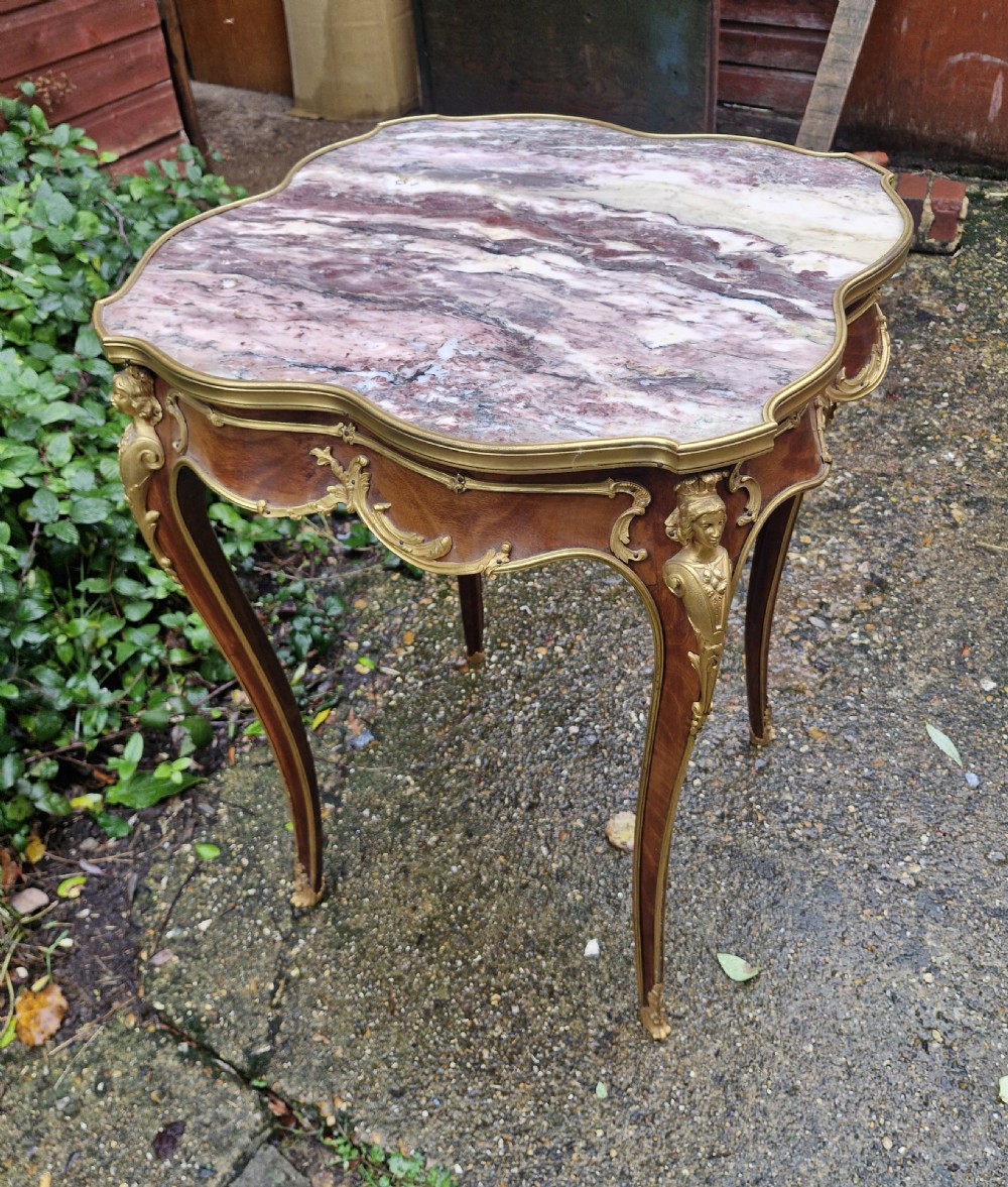 A French Louis XV style side table featuring a shaped variegated pink marble top, slender cabriole legs, and decorative gilt bronze mounts. View VIII