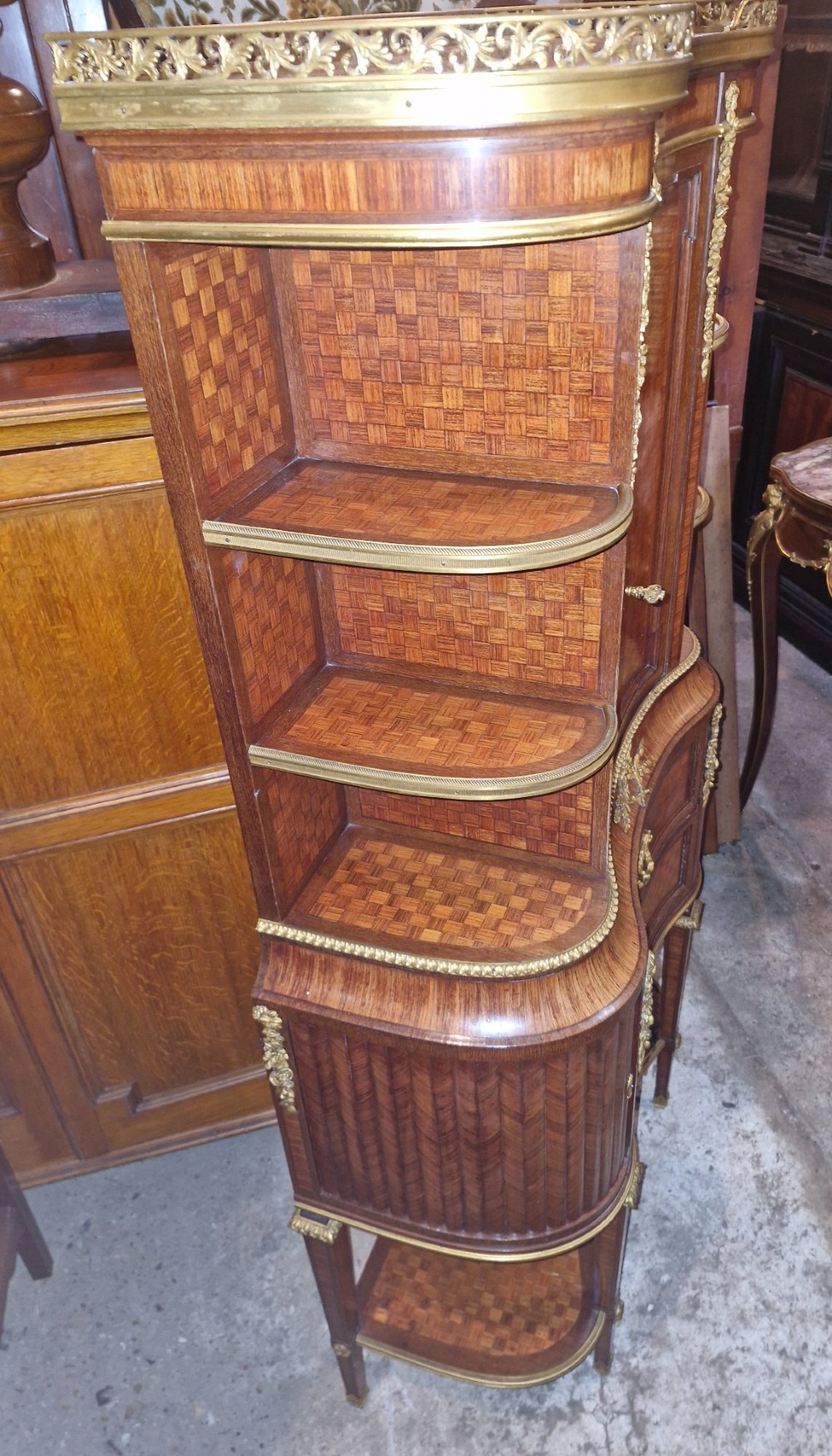 A French Louis XVI style tiered side cabinet crafted with checkerboard parquetry wood veneer, brass gallery, and ornamental ormolu mounts. View XI