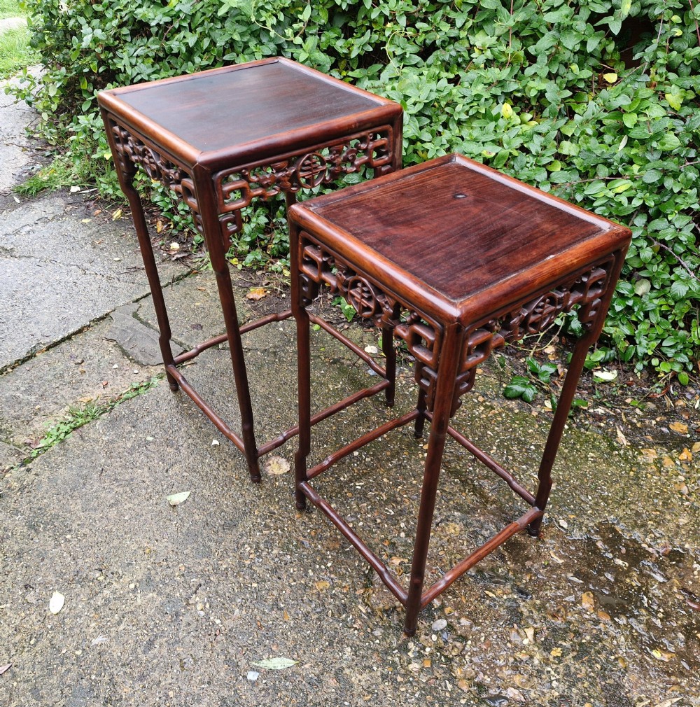 A pair of dark reddish-brown carved Chinese hardwood occasional tables of differing heights featuring bamboo-form legs and carved aprons with fretwork. View III