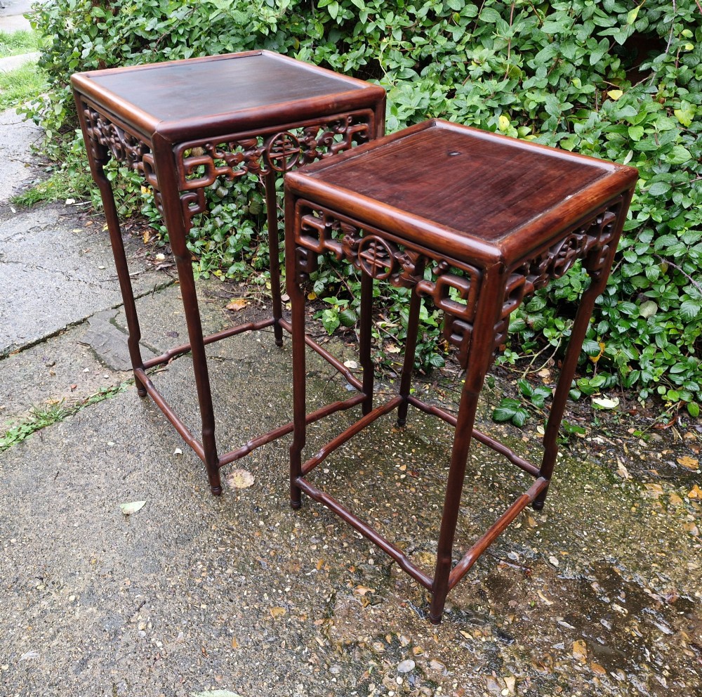 A pair of dark reddish-brown carved Chinese hardwood occasional tables of differing heights featuring bamboo-form legs and carved aprons with fretwork. View IV