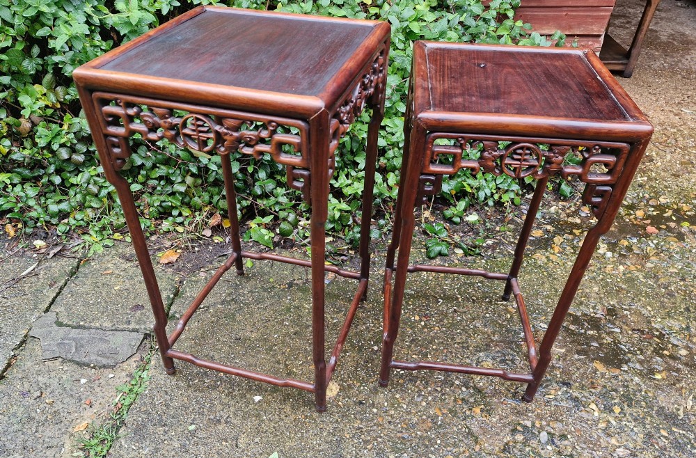A pair of dark reddish-brown carved Chinese hardwood occasional tables of differing heights featuring bamboo-form legs and carved aprons with fretwork. View VI