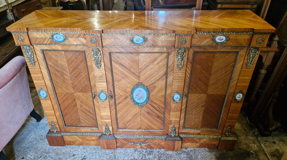 A 19th-century French parquetry side cabinet featuring three doors, brass mounts, and inset porcelain floral plaques. View II