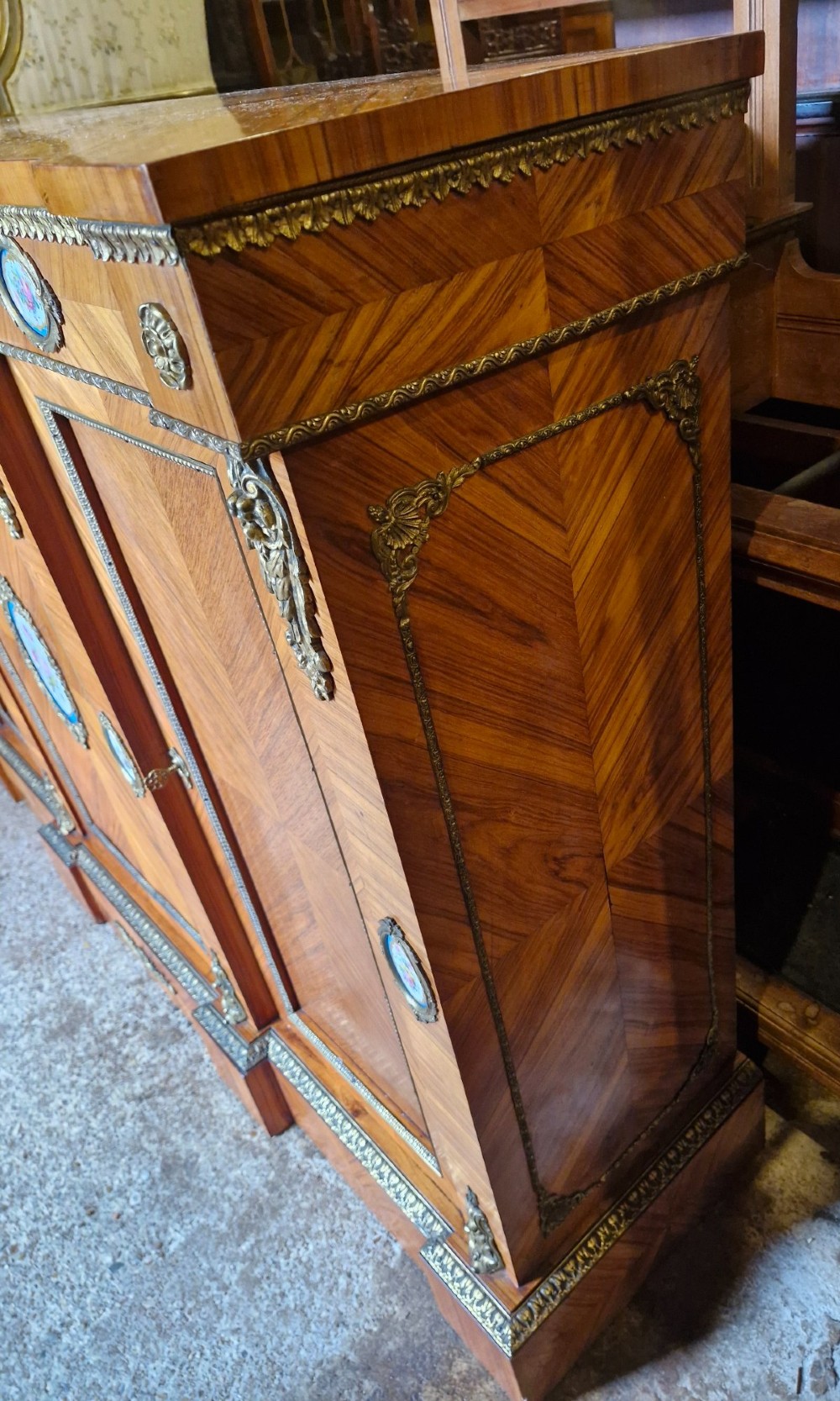 A 19th-century French parquetry side cabinet featuring three doors, brass mounts, and inset porcelain floral plaques. View III