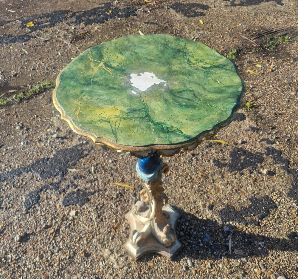 A carved and polychrome painted Italian Blackamoor pedestal stand featuring a figure in a blue top supporting a circular scalloped table top over a gilded scroll base. View VI