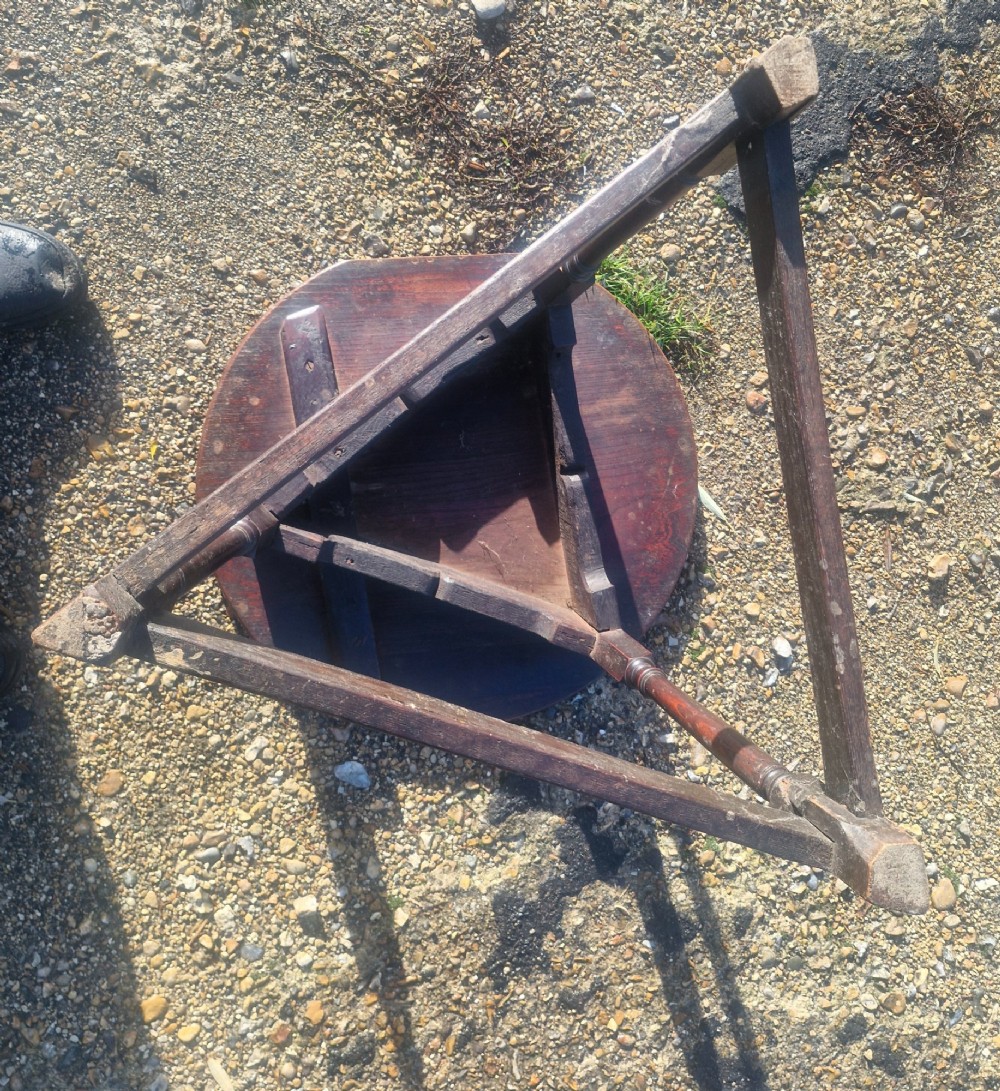An early 19th-century dark oak cricket table featuring a circular top supported by three turned legs and a lower triangular stretcher. View II