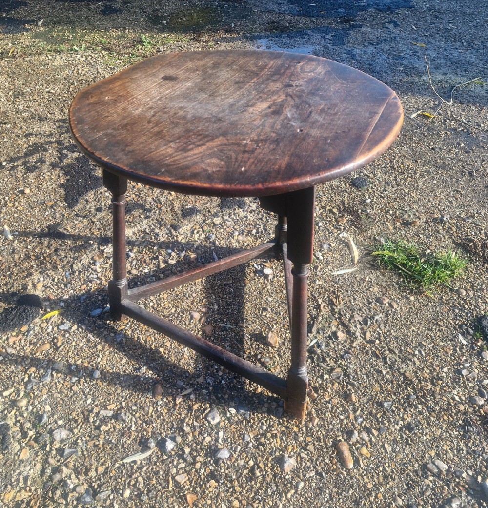 An early 19th-century dark oak cricket table featuring a circular top supported by three turned legs and a lower triangular stretcher. View IV