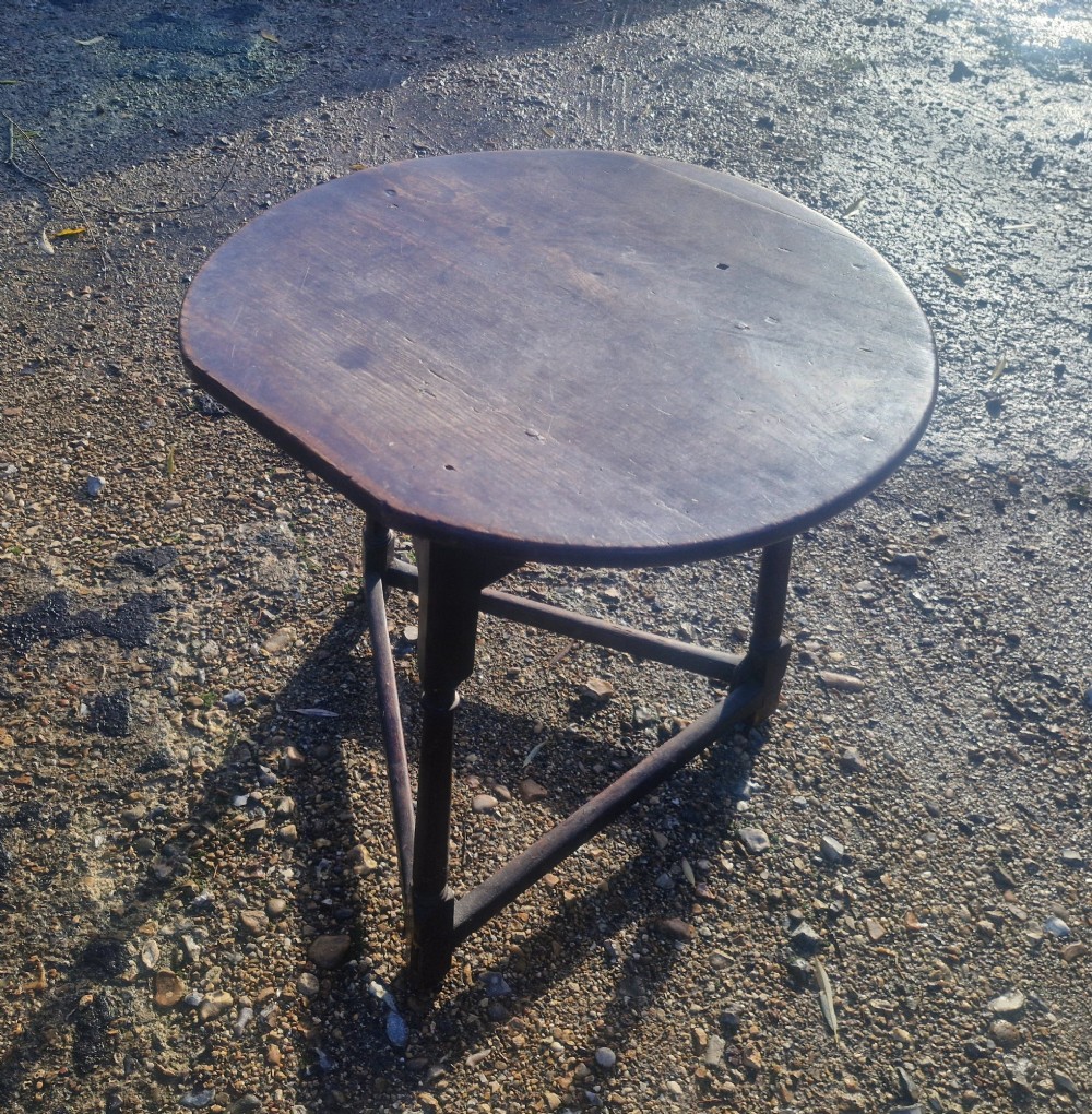 An early 19th-century dark oak cricket table featuring a circular top supported by three turned legs and a lower triangular stretcher. View VI