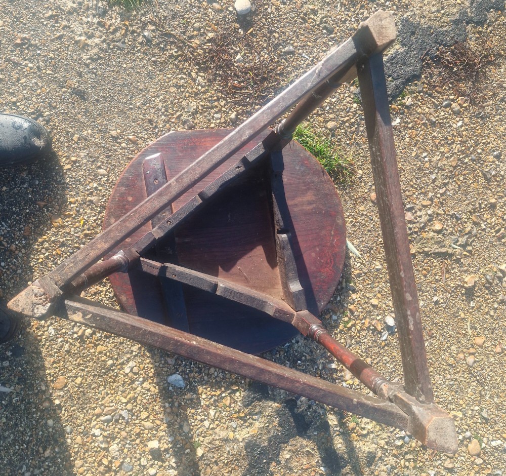 An early 19th-century dark oak cricket table featuring a circular top supported by three turned legs and a lower triangular stretcher. View VII