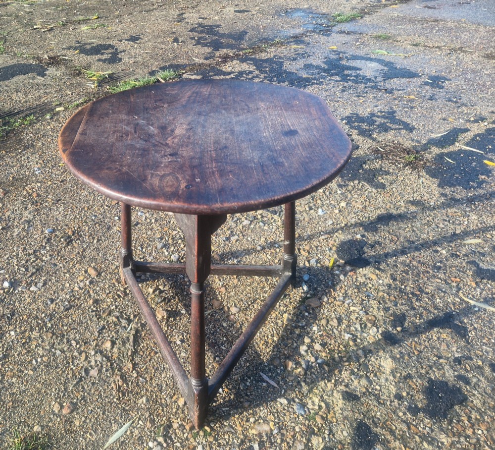 An early 19th-century dark oak cricket table featuring a circular top supported by three turned legs and a lower triangular stretcher. View VIII