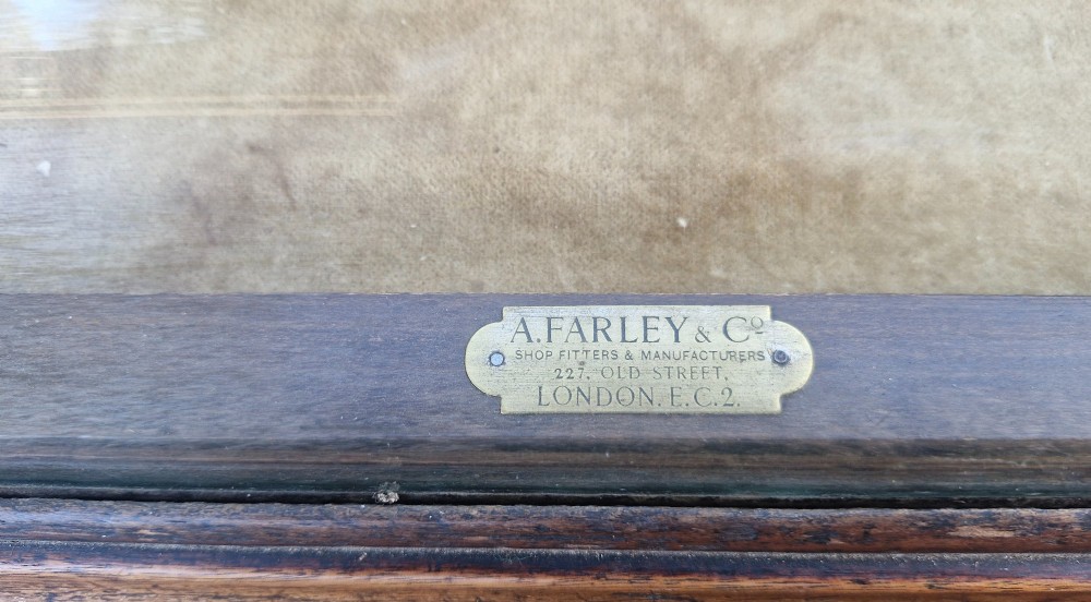 An antique dark oak tabletop display cabinet featuring a curved front glass pane and glazed top. View III