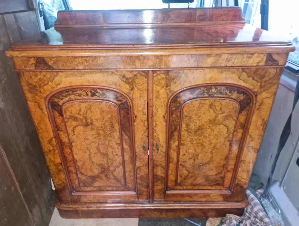 A Victorian burr walnut two-door side cabinet featuring rich natural wood grain figure, moulded arched panel doors, and a low rear upstand. View VIII