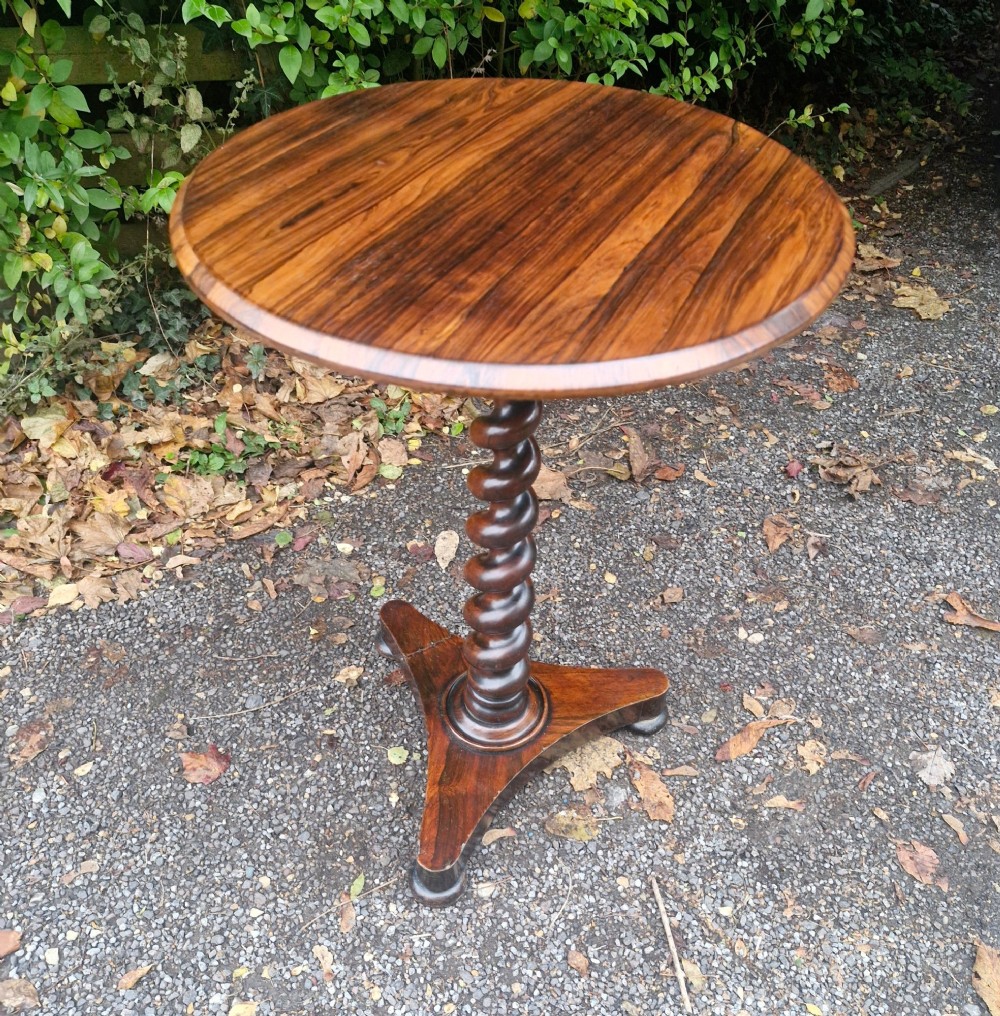 A circular mid-Victorian rosewood occasional table featuring a figured wood top, a carved spiral barley-twist central stem, and a triform platform base. View II